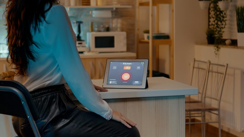 Woman looking at tablet in house with automation lighting system